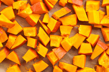 Fresh Orange Hokkaido Pumpkin Cut In Cubes On Baking Paper Ready For Baking In The Oven