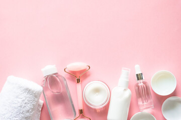 Wall Mural - skin care product, cream, serum, tonic and jade roller. natural cosmetics on pink.