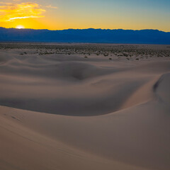 Wall Mural - Footprints in the sand. Mesquite Flat Sand Dunes and abstract geometry of curving arid desert terrain at pink sunset in Death Valley National Park, California