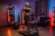 © sofiko14 - Portrait of active young woman in sportswear running using treadmill at home at night. Coronavirus Covid 19 social distance. Home workout, active adult, stay at home, remote leisure concept.