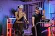 © sofiko14 - Home fitness workout sporty people caucasian woman and asian man training on exercise machines, using 3d virtual glasses imitating outdoor activities, at evening time at home.