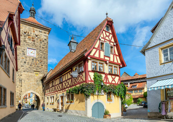 Wall Mural - Picturesque half-timbered buildings alongside the Siebersturm city gate in the historic medieval old town of Rothenburg ob der Tauber, Germany.