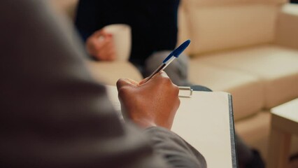 Wall Mural - Male therapist taking notes on papers at psychology session with unhappy woman, complaining about relationship problems. Counseling advisor writing report at therapy meeting. Close up.