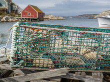 Green Lobster Cage With A Red Fisherman's House In The Background
