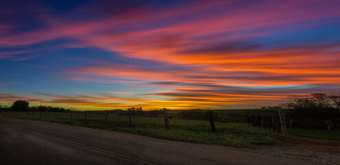 Wall Mural - panoramic and colorful sunset over the field with long exposure