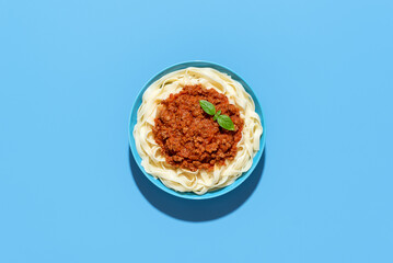 Wall Mural - Bolognese tagliatelle dish top view, isolated on a blue background