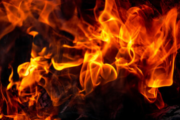 Burning fire close up. Bright orange and red flames on a dark background. Open flame heating. Problems with heating and gas.