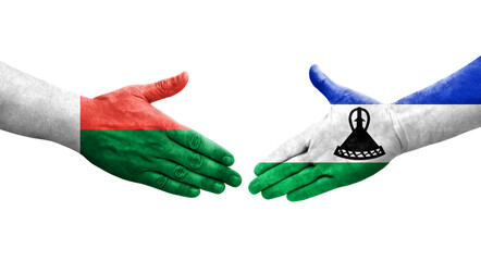 Handshake between Lesotho and Madagascar flags painted on hands, isolated transparent image.