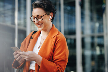 smiling businesswoman reading a text message on her phone while commuting to her office in the city