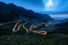 Amazing evening view with traffic lights of the north part of famous Transfagarasan serpentine mountain road between Transylvania and Muntenia in Romania