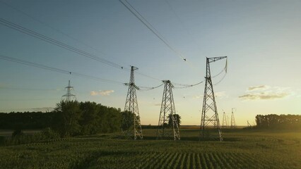 Wall Mural - High-voltage transmission towers against the sunset sky. The concept of radiation and induction field around high voltage cables