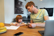 © zinkevych - Dad teaching his little son finance literacy and looking involed