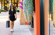 Young woman goes shopping in an outdoor outlet.