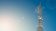 Banner With Telecommunication Tower With Many Transmitters And Receivers For Various Radio Frequencies And Data Transmission, Including 5G And Satellite At Blue Sky And Lens Flare