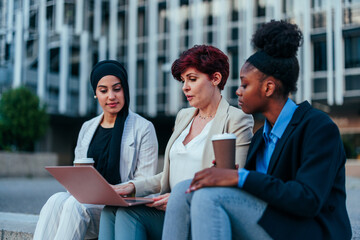 Canvas Print - Businesswomen sitting in urban area working