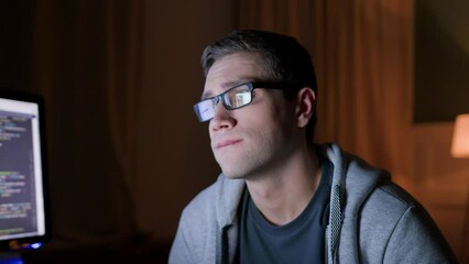 close up view of male freelancer in eyeglasses remote works at home on laptop at night darkness. programmer looks on monitor being dissatisfied, upset and frustrated. programmer gets failure in coding