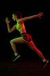 © master1305 - Running technique. Professional female jogger running isolated on dark background in neon light. Sport, fitness, speed and energy concept.