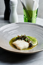 Fine Dining Plated Main Course Dish Of Halibut Filet, Wakame And Sauerkraut Puree On Marble Table 