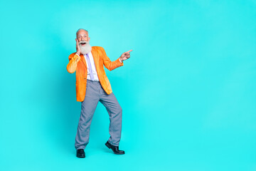 Poster - Full length photo of cool impressed retired man dressed bright orange jacket hand cheek pointing empty space isolated turquoise color background