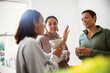 © Caia Image - Mother and young adult daughters talking at home