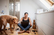 © Caia Image - Happy woman with dog and laptop on bedroom floor