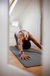 © Caia Image - Woman practicing yoga child's pose on exercise mat