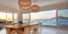 Rattan Pendant Lights Over Dining Table With Scenic Ocean View