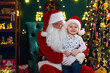 © ZaStock - Happy cute little boy sitting with Santa Claus near Christmas tree. New Year concept