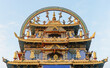 The decorative top or roof of a Buddhist temple in gold and blue