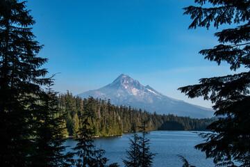 Poster - Mt Hood rises in the distance over Lost Lake in Oregon mid-afternoon.  The blue lake and green pine trees from the majestic mountain. 