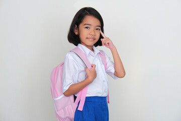 Wall Mural - Asian little kid wearing school uniform smiling while pointing to her brain