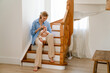 © Drobot Dean - Young white mother wearing shirt holding her baby in arms at home