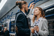 © yurolaitsalbert - young couple in love with a takeaway coffee standing in a subway car.