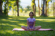 © amnaj - Yoga in the park. Young Asian woman practicing yoga pose at the park.