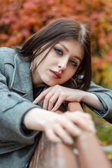 Cute girl on a bench in the autumn park.