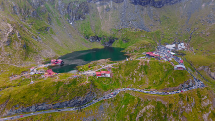 Drone photography of Balea lake, on Transfagarasan road, Romania. Photography was shot from a drone from a higher altitude with the lake and cabins in the view and the mountain in the background. 