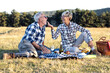 © pucko_ns - Mature couple sitting on blanket in nature and make picnic. She feed old man with piece of food and smile