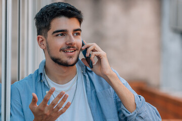 Wall Mural - young millennial or student talking on the phone in the street