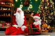 © ZaStock - Little boy getting big Christmas gift from Santa Claus. Christmas Scenes. New Year concept