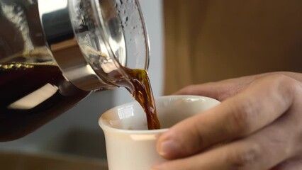 Wall Mural - Slow motion of hands pouring coffee from its server into a ceramic cup