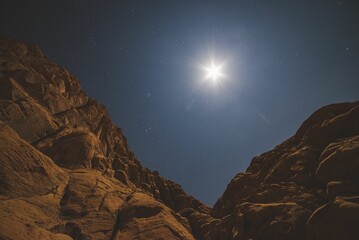 Wall Mural - scenic view of huge canyons in the desert under the starry sky with the shining moon
