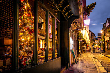 A Chirstmas night view of Shambles, a historic street in York featuring preserved medieval timber-framed buildings with jettied floors