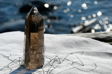 Wall Mural - A close up image of a large smokey quartz crystal tower on a large piece of driftwood.