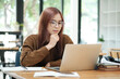 © ijeab - Young woman studying or working online using laptop.