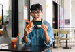 © Q88 - Portrait of Asian male student sitting at a coffee shop