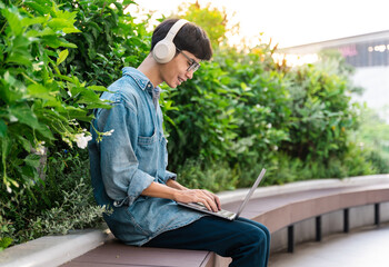 image of asian boy sitting and using computer in school campus