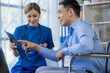© ArLawKa - Asian female doctors encourage and support male patients in wheelchairs after consulting and health check in the concept of hospital, clinic