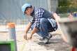 © auremar - construction worker measuring foundations at site