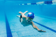 Latin Child Boy Swimmer Wearing Cap And Goggles In A Swimming Underwater Training In The Pool In Mexico Latin America	