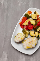 Poster - baked vegetables with boiled fish on white plate